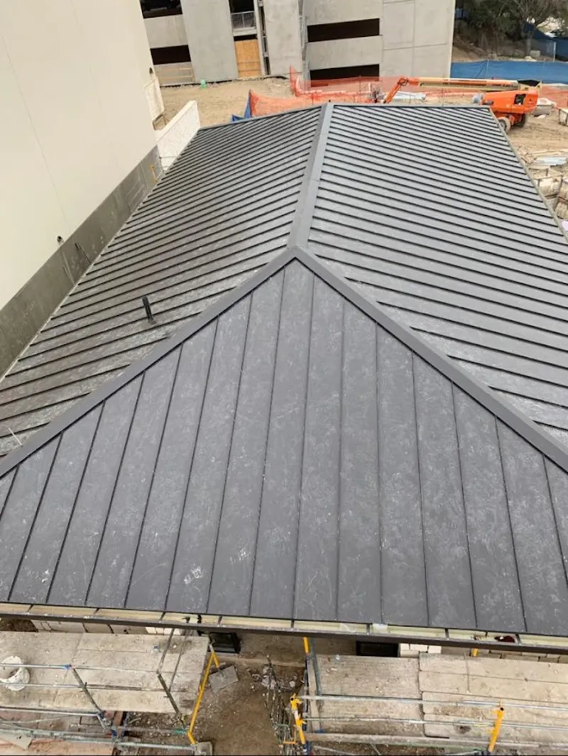 Commercial metal roof construction with crane equipment in College Park